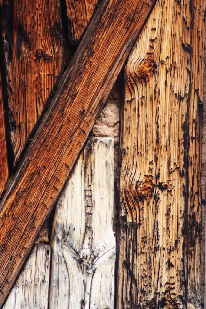 Close-up of weathered, rustic wooden planks arranged in a textured pattern, highlighting natural grains.